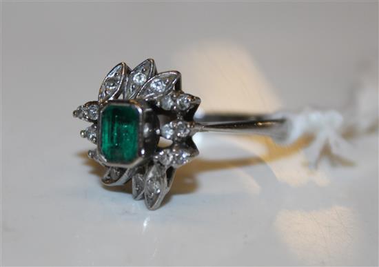 A 14ct white gold, emerald and diamond cluster ring, size O.